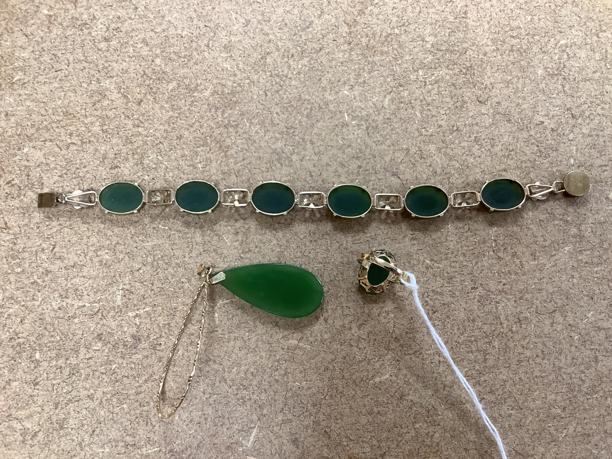 A 14k yellow metal and cabochon jade set bracelet, 18.5cm, gross 13.3 grams, an 18k mounted jade pendant and dress ring, gross 8.5 grams.